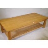 A solid golden oak two tier coffee table, bears label New Forest Furniture Ltd, 66" x 30" x 18"