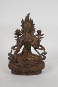 A Sino Tibetan gilt bronze figure of a seated female deity, 8½" high