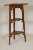 An Arts and Crafts oak three tier corner whatnot, 36½" high