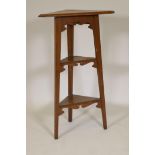 An Arts and Crafts oak three tier corner whatnot, 36½" high