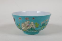 A polychrome porcelain rice bowl with enamelled bird and floral decoration  on a turquoise ground,
