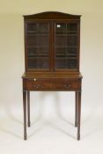 A C19th mahogany writing table, the upper section with two glazed doors, the lower with reeded