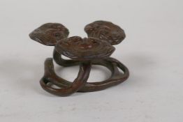 A Chinese bronze brush rest in the form of entwined ruyi, 2" diameter