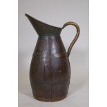 An antique coopered oak pitcher with brass handle, 23" high