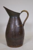 An antique coopered oak pitcher with brass handle, 23" high