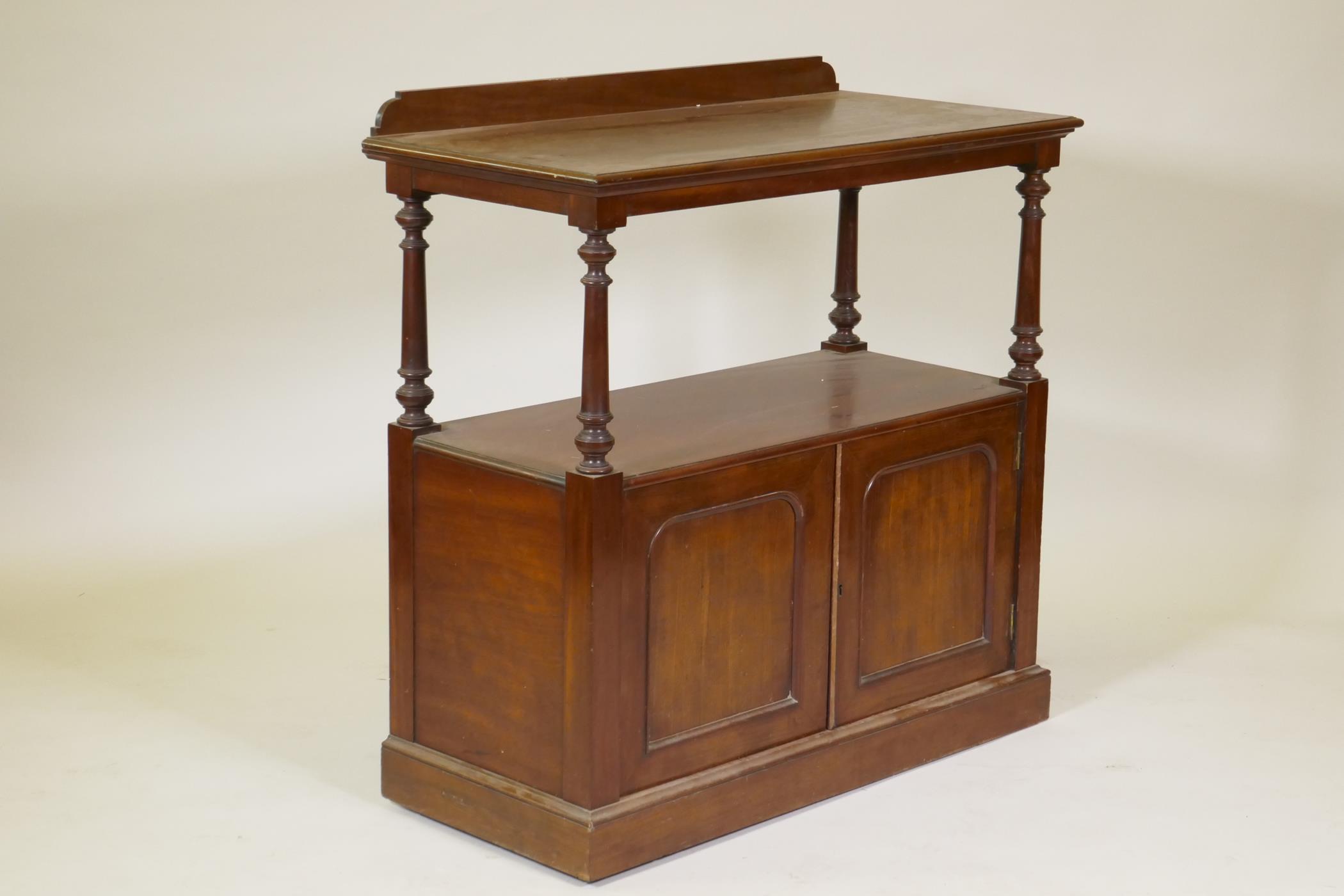 A Victorian mahogany two tier buffet, the top with shaped back raised on tapering turned supports