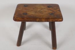 An C18th/early C19th elm footstool on four shaped supports, 8" x 10" x 7"