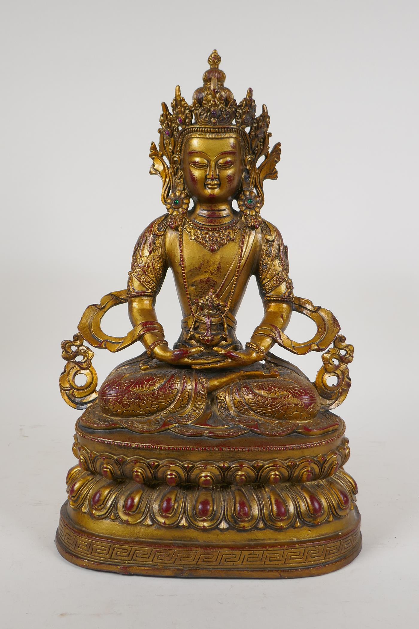 A Sino Tibetan gilt bronze figure of Buddha seated on a lotus throne, 14½" high