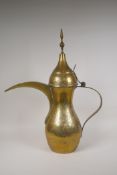 A Turkish brass coffee pot with chased floral decoration, 23½" high