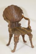 A C19th grotto chair, carved shell back and seat and arms in the form of dolphins, raised on