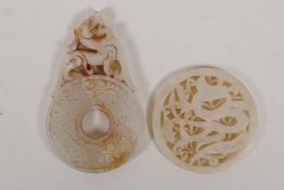 A Chinese carved and pierced white jade pendant with dragon decoration, and another in the form of a