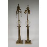 A pair of brass classical style column table lamps with swirled glass reservoirs, 29" high