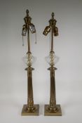 A pair of brass classical style column table lamps with swirled glass reservoirs, 29" high