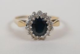 A 9ct yellow gold ring set with a blue stone encircled by diamonds, size Q/R