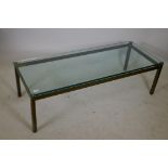 A bespoke solid brass coffee table with a plate glass top, 22" x 56" x 17"