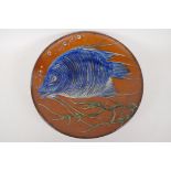 A large studio pottery charger with tube liner and painted decoration of a fish, signed, 13½"