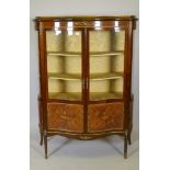 A French marquetry inlaid mahogany serpentine front vitrine with brass mounts, the interior with