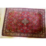 An oriental Maymeh wool carpet with all over geometric designs and central medallion on a red field,