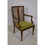 A Victorian inlaid mahogany open arm chair with slat back and shaped arms, raised on tapering