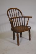 A C19th child's Windsor hoop back elbow chair, with elm  seat, raised on turned supports, AF