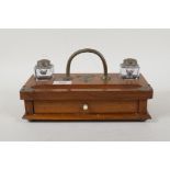 An Arts & Crafts oak desk stand with two glass inkwells and base drawer containing a quantity of dip