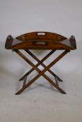 A stained pine butlers tray and stand, with brass hinged drop sides, 19" x 29"