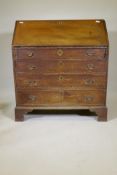 A Georgian oak fall front bureau, with fitted interior  over four long drawers, raised on bracket