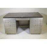 A mid C20th brushed steel industrial style kneehole desk with rubberised top, fitted with five