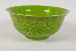 A lime green glazed porcelain rice bowl with raised dragon decoration, Chinese Qianlong seal mark to