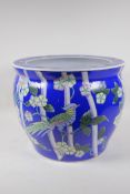 A Chinese blue ground ceramic jardiniere with famille rose decoration of asiatic birds and