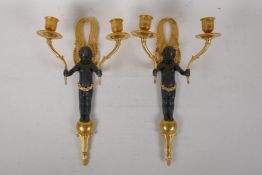 A pair of bronze and ormolu two branch wall sconces in the form of winged putti, 7½" x 14"