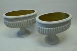 A pair of painted wood wine coolers with gilt metal liners, raised on carved pedestal supports,