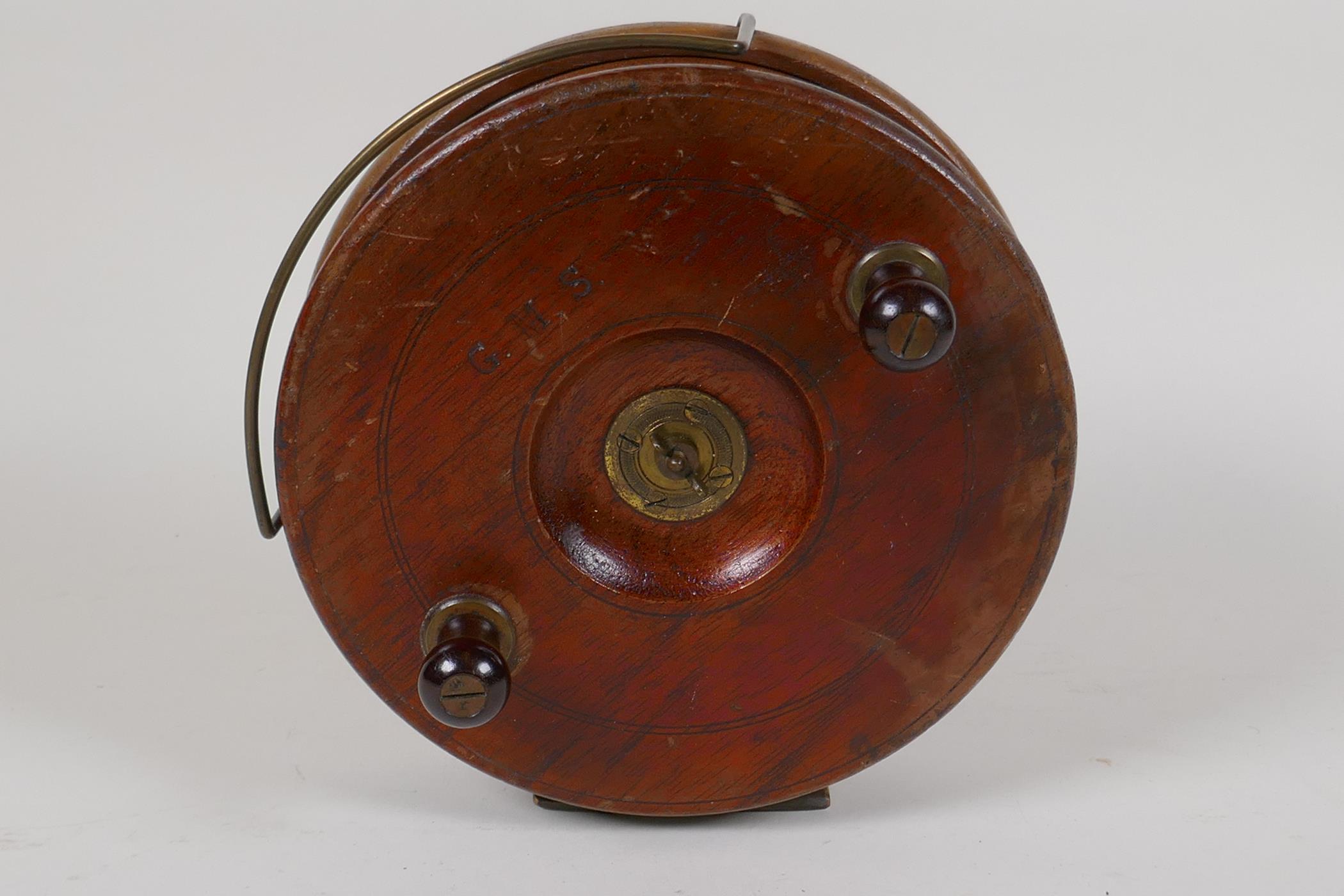 A vintage mahogany and brass Starback fishing reel, 7" diameter