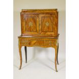 A C19th French tulipwood bonheur de jour with ormolu mounts, the upper section with a shelf behind