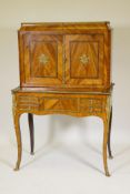 A C19th French tulipwood bonheur de jour with ormolu mounts, the upper section with a shelf behind