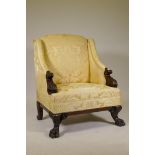 An imposing wing back armchair in the manner of William Kent, with carved and scrolled arms,