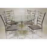 A contemporary glass top dining table raised on a chrome metal base, and four chairs ensuite