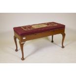 An Essenby mahogany duet stool with woolwork upholstered lift up seat, raised on cabriole