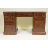 A Victorian walnut nine drawer kneehole desk, with inverted breakfront and inset top, raised on a