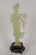 A carved green hardstone figure of a Chinese lady, on a carved hardwood base, 8" high