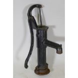 A vintage cast iron water pump painted black, 27" long