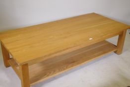 A solid golden oak two tier coffee table, bears label New Forest Furniture Ltd, 66" x 30" x 18"