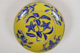 A Ming style yellow ground porcelain dish with blue and white flower and fruit decoration, Chinese