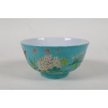 A polychrome porcelain rice bowl with enamelled bird and floral decoration  on a turquoise ground,