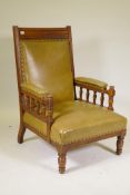 A Victorian walnut armchair with studded leather upholstery and open arms, raised on turned supports