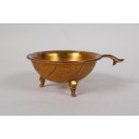 A Chinese gilt metal cup with kylin, floral and bird decoration, raised on tripod supports, 3½"