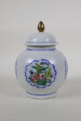 A polychrome porcelain ginger jar and cover, with enamelled decorative panels depicting flowers,