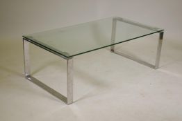 A designer glass topped coffee table on chrome end supports, 43" x 23½", 15" high