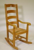 A beech wood ladderback rocking chair with rush seat