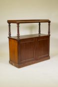 A C19th mahogany two tier buffet, the top with three quarter gallery and raised on turned